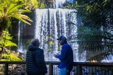 Guide talking in front of Tasmanian waterfall